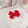 Fermaglio per bambini con fiocco in tessuto rosso a pois bianchi su un piatto bianco - Tessuto N. 5 - Pois Rossi