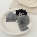 Detalle de un coletero de lazo tejido en gris con un colgante de cara sonriente - Gris con Lazo