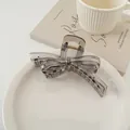 Dettaglio molletta a fiocco grigio traslucido su un piatto di ceramica bianca - Grigio Trasparente
