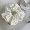 Detailed view of white pleated satin scrunchie on decorative glass tray for hair styling - 1# Creamy White