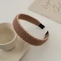 Nahaufnahme eines braunen Plüsch-Stirnbands mit weißer Spitze an einer Kaffeetasse - Kaffee
