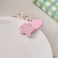 Close-up of a pink matte bear hair clip with a stylish checkered pattern and gold heart detail - Pink