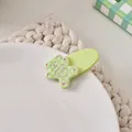 Close-up of a green checkered bear hair clip with HIME text on a white porcelain plate - Light Green