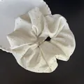 Détail d'un chouchou crème avec strass sur une assiette décorative blanche - Blanc avec Strass