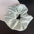 Gros plan d'un chouchou vert menthe avec strass argentés brillants sur une assiette - Vert menthe avec strass