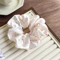 Close-up of pink polka dot satin scrunchie on a decorative jewelry tray for hair styling - White Pink Polka Dot