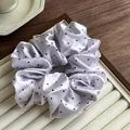 Dettaglio dell'elastico in raso lavanda a pois neri con una piccola etichetta laterale - Viola Pois Neri