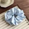 Dettaglio di un elastico in raso celeste a pois bianchi su un vassoio da esposizione - Blu Pois Bianchi