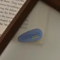 Dettaglio della molletta a goccia in acetato blu con logo France Handmade dorato - Blu Gelatina