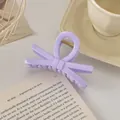 Détail d'une pince à cheveux nœud lavande avec ressort doré posée sur un livre - Nœud / 9cm / Violet Clair