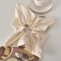 Detailed shot of cream floral embroidered scrunchie with a lifestyle background - White Square Scarf Style