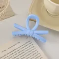 Détail de la pince à cheveux nœud bleu clair sur livre avec un design minimaliste - Nœud / 9cm / Bleu Lait