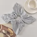 Macro shot of embroidered white floral patterns on a light blue cotton scrunchie - Blue Bow Style