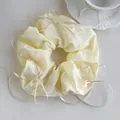 Detailed view of cream-colored oversized scrunchie with elegant flowing satin ribbons - Milk Yellow