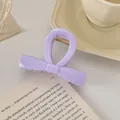 Détail d'une pince à cheveux nœud lavande avec ressort doré sur un livre ouvert - Décoration de Nœud / 8cm / Violet Clair