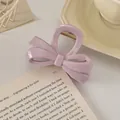 Nahaufnahme der hellvioletten Schleifen-Haarklammer mit goldener Feder auf Buch - Prinzessinnen-Schleife / 8.5cm / Altrosa