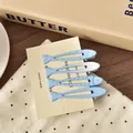 Nahaufnahme von vier süßen blauen Haarclips in Fischform auf einer Schmuckkarte - Blauer Fisch Stil