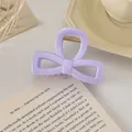 Détail d'une pince à cheveux nœud lavande avec ressort en métal sur un livre - Nœud Évidé / 8cm / Violet Clair