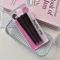 Detailed view of three professional black hair clips in packaging inside a blue basket - Black