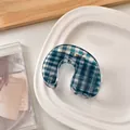 Close-up of blue and white gingham check U-shaped hair claw made of acrylic material - U-Shaped