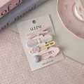 Pastel pink and blue bow hair clip set with wave patterns and heart detail on card - Pink Cross Style