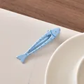 Simpatica molletta per capelli a forma di pesce azzurro su carta bianca - Pesce Blu Sorridente