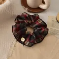 Retro plaid scrunchie with red and black check patterns and a brown ribbon bow detail - Red Plaid Button Scrunchie