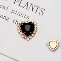 Dettaglio di un cristallo a cuore nero con strass e base in metallo dorato - Base Oro Nero