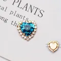 Dettaglio macro del cristallo a cuore blu lago con castone dorato e quattro fori da cucito - Oro Strass Blu Lago