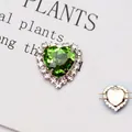 Vista macro del cristallo a cuore verde smeraldo con griffe in metallo per il DIY - Base Argento Verde Erba
