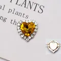 Vista macro di cristallo a cuore giallo con strass bianchi e retro in metallo traforato - Base Argento Giallo Oro