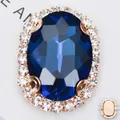 Makroansicht ovaler blauer Kristall mit Krallenfassung und Strasssteinen zum Nähen - Goldene Basis Pfauenblau