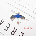 Macro-opname van 2,8x3,7 cm vogelvormige emaille hanger met gouden randen en blauwe details - Vogel