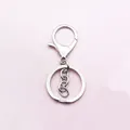 Dettaglio della chiusura a moschettone in metallo argento e portachiavi piatto con catena - Stile Catena Corta / Argento
