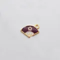 Detailed macro view of purple and white fan-shaped enamel pendant with golden trim for DIY jewelry - Fan