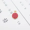 Macro shot of pink enamel flower pendant with golden alloy base and hanging ring - Wreath