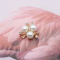 Goldenes Blumen-Accessoire mit drei großen Perlen und glitzernden Strasssteinen für DIY - Reinweiß