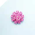 Detailansicht eines rosa Blumendekors mit funkelnden Strasssteinen auf blauem Grund - Rosa
