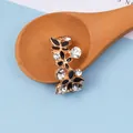 Nahaufnahme von blumenförmigem Legierungszubehör mit schwarzer Emaille und Kristallen - Schwarz