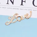 Nahaufnahme des goldenen Love-Anhängers mit glitzernden Strasssteinen und Herzform - Einzelnes LOVE