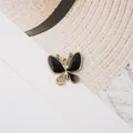 Makroaufnahme: Schmetterlingsanhänger in Gold mit schwarzer Emaille und Strass für DIY-Schmuck - Schwarz