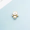Detail van bloem haaraccessoire met wit emaille blaadjes, strasstenen en parels - Wit