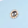 Detail view of oval flower pendant with dark gray center stone and white rhinestones - Gray