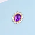 Close-up of oval purple gemstone alloy accessory with white rhinestones and gold plating - Purple