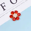Dettaglio del ciondolo a fiore in cristallo rosso con base dorata e pietre bianche - Rosso