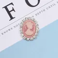 Close-up of pink cameo accessory with ivory relief and shimmering crystal rim - Pink
