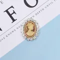 Detailed macro view of oval vintage cameo pendant with clear rhinestone border trim - Yellow