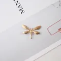 Dettaglio di accessorio in lega dorata a forma di libellula con trame in rilievo fini - Libellula Piena