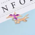 Detail of bird-shaped gold alloy charm with purple enamel wings and flower accents - Right Side Purple