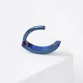 Macro detail of a navy blue titanium steel hinged piercing ring on white stone - Blue